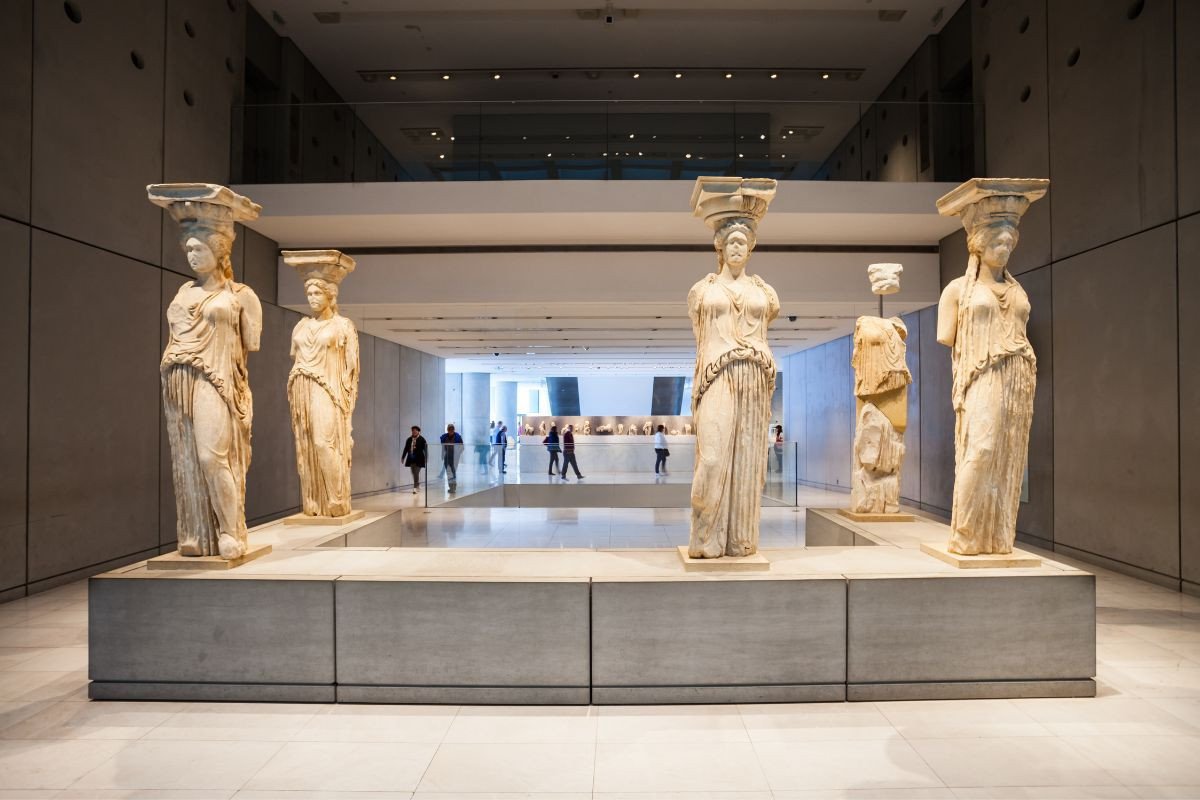 The Caryatids, ancient Greek statues of women, on display at the Acropolis Museum in Athens, Greece, showcased in a modern, well-lit interior space.